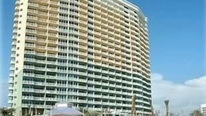 A high-rise hotel with multiple balconies and a curved facade.