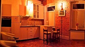 A cozy kitchen with wooden beams, a stone wall, and a window. - Style, space and security in ultra central location in Brasov (Brașov)