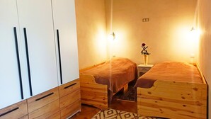 A small, cozy room with two wooden beds, a wardrobe, and a nightstand with a vase of flowers. - Style, space and security in ultra central location in Brasov (Brașov)