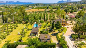 Un quartier résidentiel avec une grande maison dotée d’une piscine, entourée d’une végétation luxuriante et offrant une vue dégagée sur la mer.