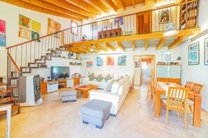 Ein geräumiges Wohnzimmer mit Treppe, Essbereich und Küche.