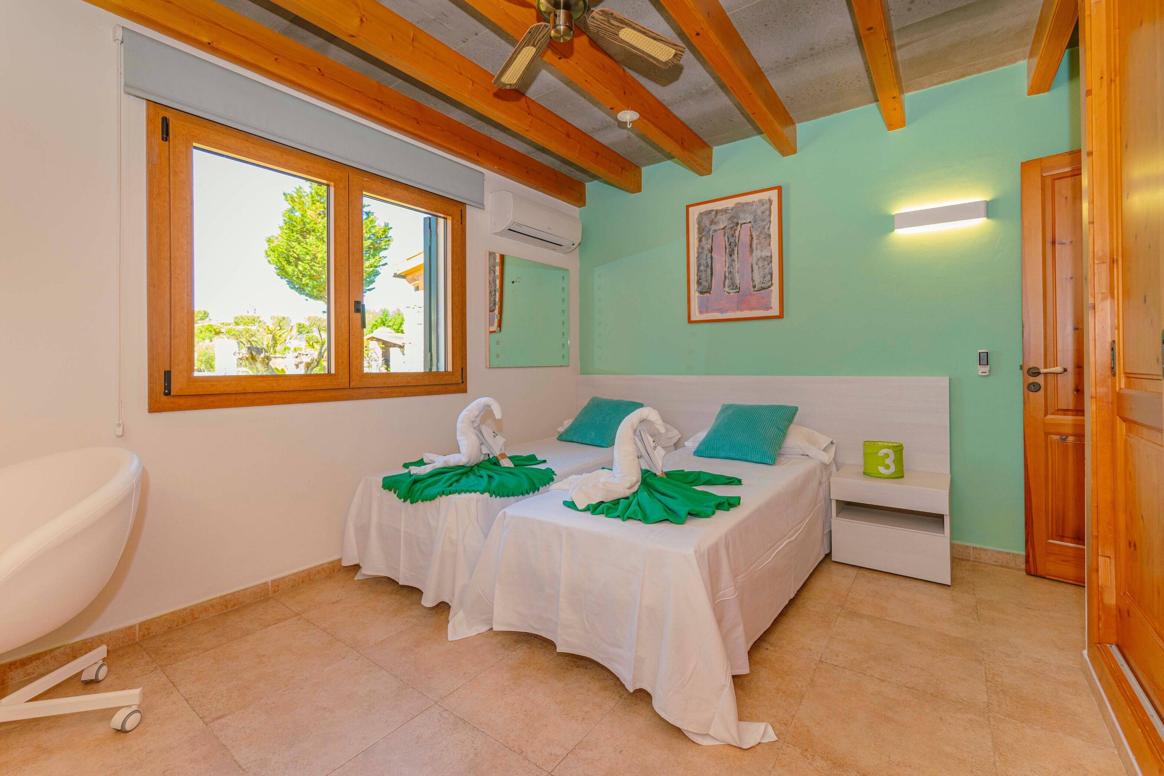 Une chambre d’hôtel avec deux lits, une fenêtre, une salle de bain et une porte.