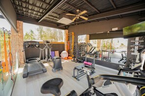 A gym with treadmills, exercise bikes, and free weights.
