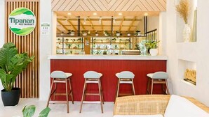 A restaurant interior with a wooden ceiling, a counter with stools, and potted plants. - Hortz Hotels and Resorts (Tagaytay)