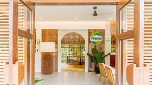 A restaurant entrance with a sign reading "Tipanan Restaurant," a wooden interior, and a seating area visible through the glass doors. - Hortz Hotels and Resorts (Tagaytay)