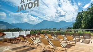 Una terrazza con lettini e vista sulle montagne.