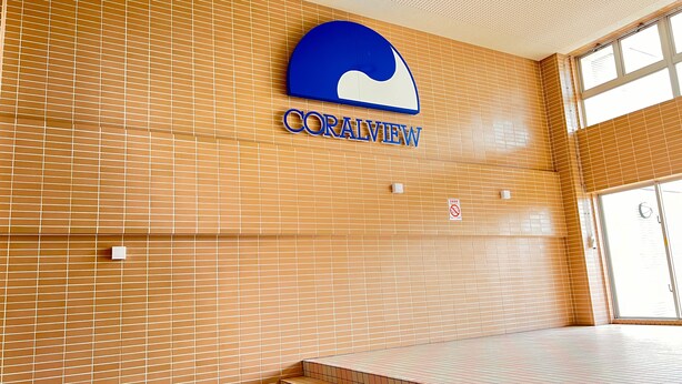 Un mur recouvert de carreaux, sur lequel on peut lire l’inscription « CORALVIEW » et un panneau indiquant qu’il est interdit de fumer.