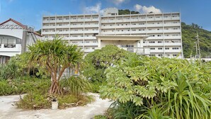 Un immeuble à plusieurs étages, doté d’un toit plat et d’une entrée centrale.