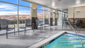 A pool area with chairs and tables, large windows, and a view of the landscape. - Fairfield Inn & Suites by Marriott Klamath Falls (Klamath Falls)
