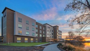 A modern hotel with multiple floors, a covered outdoor area, and a pathway leading to a body of water. - Fairfield Inn & Suites by Marriott Klamath Falls (Klamath Falls)