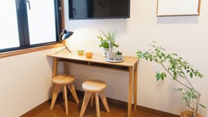 A small wooden desk with two stools, a potted plant, and a television mounted on the wall. - Near Ikebukuro, Kitchen & Laundry, Fast Wi-Fi, 4min to Station,Many restaurants nearby!! (Tokyo)