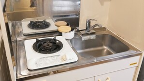 A kitchenette with a gas stove, a sink, and wooden cutting boards. - Near Ikebukuro, Kitchen & Laundry, Fast Wi-Fi, 4min to Station,Many restaurants nearby!! (Tokyo)