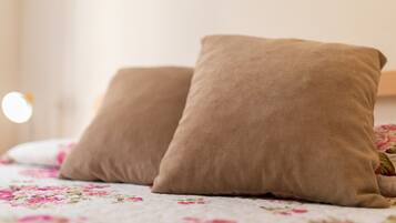 Una cama con ropa de cama floral y dos almohadas beige.