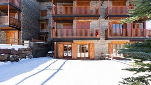 Un immeuble à plusieurs étages, doté de balcons, de murs en pierre et de portes en bois.