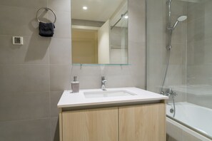 Apartamento | Banheiro | Chuveiro com efeito de chuva, toalhas de banho, sabonete, shampoo