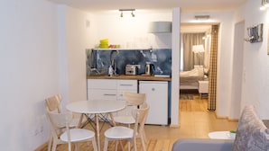 Ein kompakter Wohnraum mit Küchenzeile, Essbereich und Schlafzimmer.