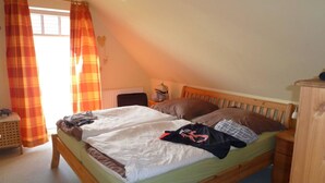 Un lit simple avec un cadre en bois, une table de chevet, une lampe et un radiateur.