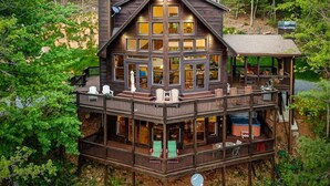 A multi-level wooden cabin with a balcony, a hot tub, and outdoor seating. - Altitude Adjustment | Cherry Log, Ga (Cherry Log)