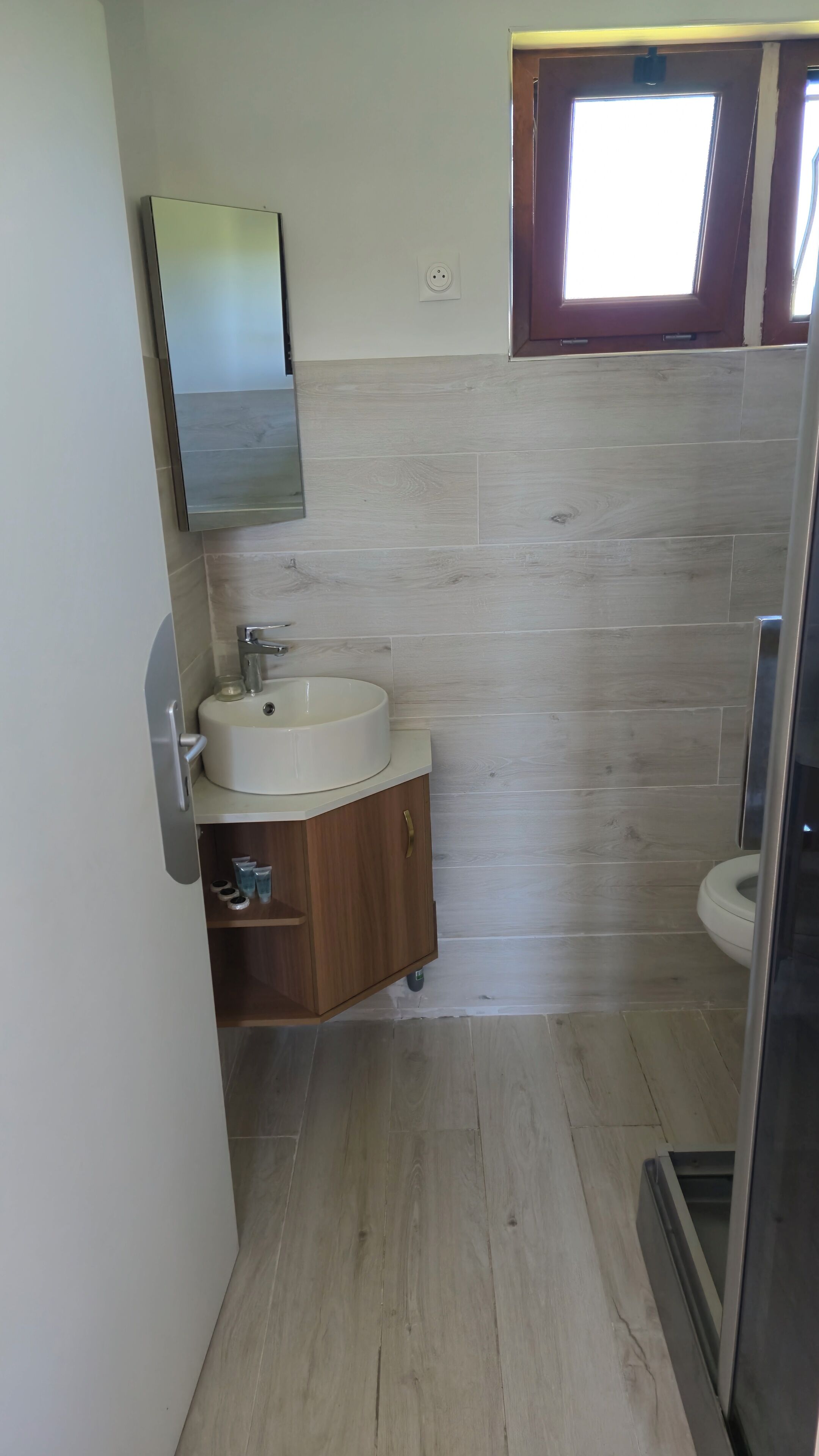 Une salle de bain avec un lavabo, un miroir et des toilettes.