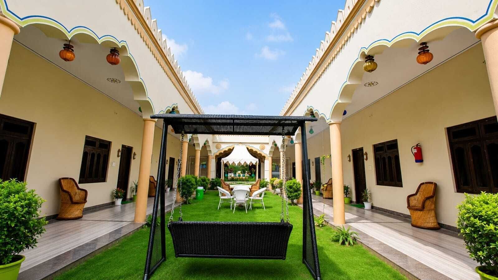Un patio con una hamaca, sillas y una mesa.