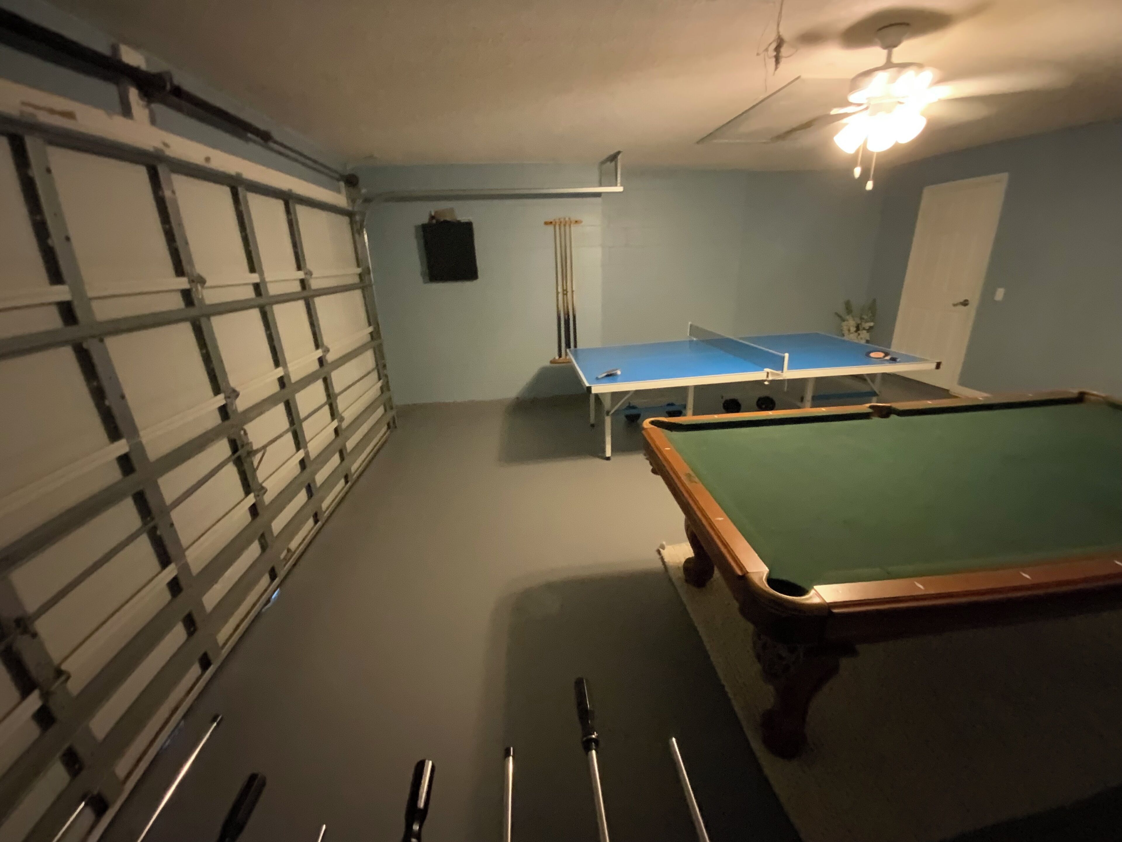 Une pièce équipée d’une table de billard, d’une table de ping-pong et d’un porte-queue.