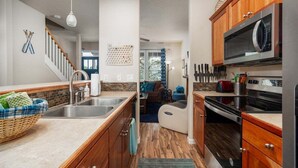 Une cuisine moderne avec des meubles en bois, des appareils en acier inoxydable et un îlot central.