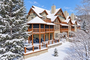 Un chalet à plusieurs étages doté d’un balcon et d’un espace extérieur aménagé et couvert.