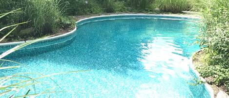 Una piscina al aire libre, una piscina climatizada