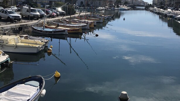 A marina with boats docked, a clear sky, and buildings along the water. - Cozy duplex apartment on the quays of Sète (Sète)