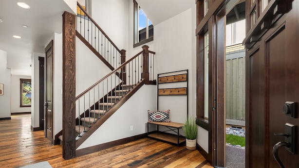 A spacious hallway with a wooden staircase, a bench, and a potted plant. - Luxury Home in Suncadia! Great Value * Hot Tub * Specials! (Cle Elum)