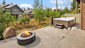 A backyard with a fire pit, hot tub, and a stone fireplace. - Luxury Home in Suncadia! Great Value * Hot Tub * Specials! (Cle Elum)