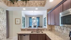 A modern kitchen with granite countertops, stainless steel appliances, and wooden cabinets.