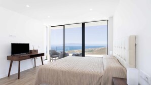 A modern bedroom with a large bed, a desk, a chair, and a television. - "New Home Costa Adeje, Luxurious Private Villa" (Costa Adeje)