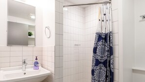 A modern bathroom with a white sink, mirror, and shower. - Downtown Retreat: Stylish Boston Studio (Boston)