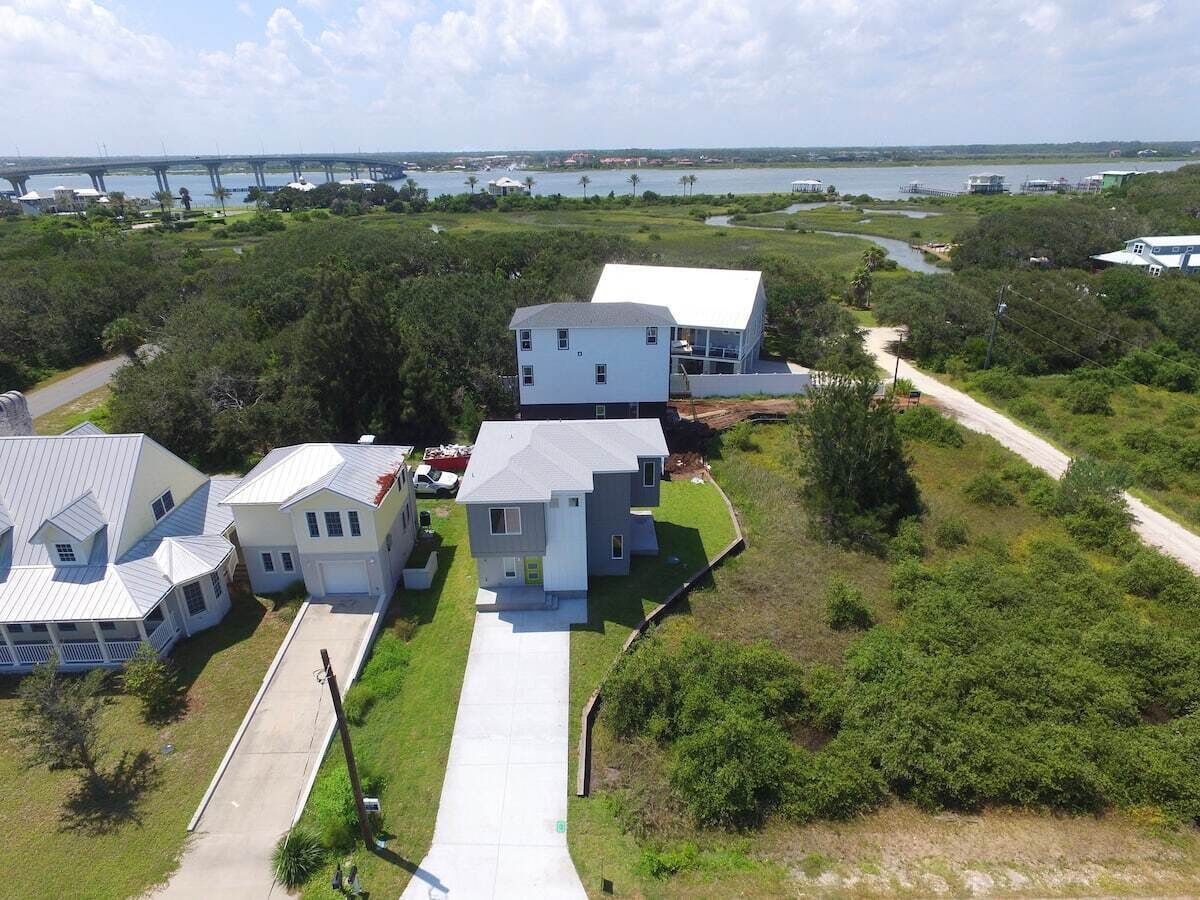 A residential area with houses, a bridge, and a body of water.