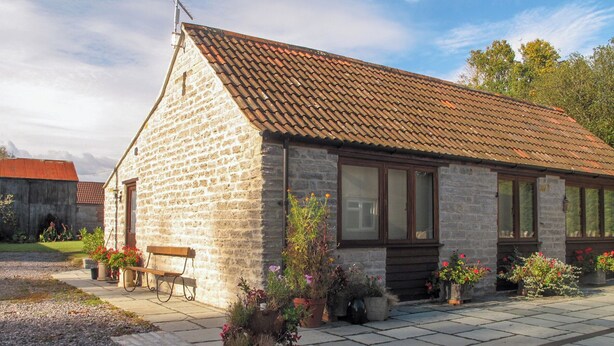 A stone building with a tiled roof, a bench, and potted plants. - 2 bedroom accommodation in Lovington, near Somerton (Lovington, near Somerton)