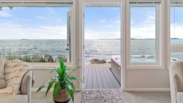 Ein Zimmer mit Meerblick, einer Whirlwanne und einer Topfpflanze.