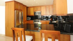 Una cucina moderna con mobili in legno, elettrodomestici in acciaio inossidabile e un piano di lavoro in granito.