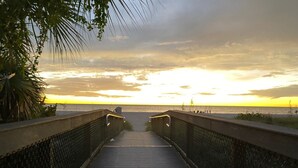 A wooden boardwalk leading to a beach with a sunset in the background. - Bayshore Beach House - Walk to Nokomis Beach!  Close to Siesta Key, Venice Beach (Nokomis)