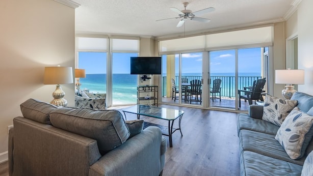A spacious living room with a large window overlooking the ocean, a ceiling fan, and a flat-screen TV. - Great beachfront condo!  Best View in Destin! Jade East Towers unit 920! (Destin)