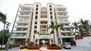 A multi-story hotel with a central entrance, balconies on each floor, and a symmetrical facade.