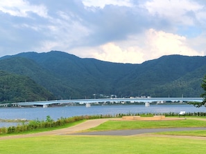 Uma ponte sobre um lago, com montanhas ao fundo.