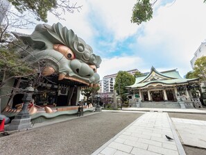 A traditional building with a curved roof and a large dragon statue in front.