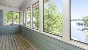 A room with large windows overlooking a lake and dock area. - Secluded Lake Home (Dadeville)