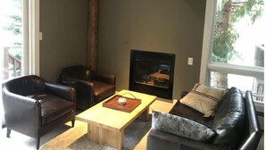Ein Wohnzimmer mit Kamin, Ledersofas und einem Holztisch.