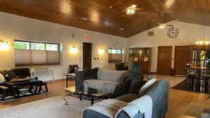 Ein geräumiges Wohnzimmer mit einer großen Couch, einem Couchtisch und einem Essbereich mit Holztisch und Stühlen.