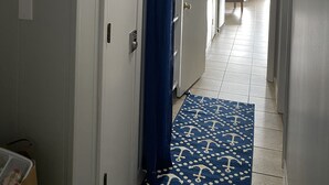 A hotel hallway with a ceiling fan, a painting of sailboats, a sign that says "STAY anchored", and a blue carpet with anchor patterns. - Beautiful Ocean View/ Steps to Beach and Pool (Hilton Head Island)