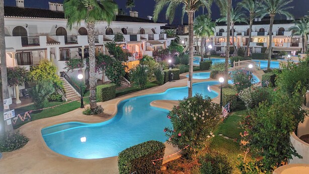 A resort with multiple swimming pools, palm trees, and a building with balconies. - Beachfront in Denia Alicante (Dénia)