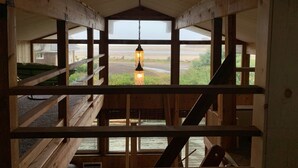 Un interior de madera con vistas a una playa a través de amplios ventanales.