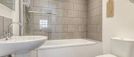 Une salle de bain avec une baignoire, un lavabo et des toilettes.
